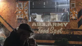 Mieszkaniec Kijowa ogrzewa się ciepłą herbatą Fot. PAP/EPA/MAXYM MARUSENKO