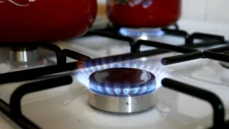 Kuchenka gazowa z zapalonymi palnikami. Fot. PAP/Adam Hawałej