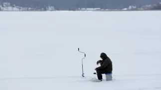 Wędkarz podlodowy na zamarzniętym jeziorze Niegocin Fot. PAP/Tomasz Waszczuk