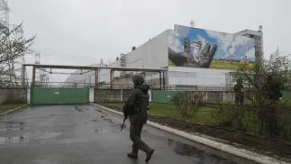 Uzbrojony bojownik Gwardii Narodowej maszeruje przed elektrownią jądrową w Czarnobylu Fot. PAP/EPA/SERGEY DOLZHENKO