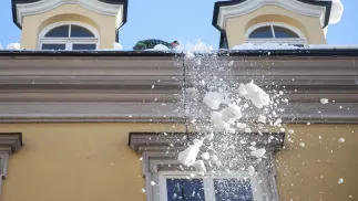 Spadający z dachu budynku śnieg. Fot. PAP/Łukasz Gągulski