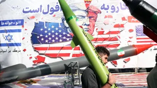 Іранський чоловік несе макет ракети, проходячи повз карикатуру, що зображує президента США Дональда Трампа, Тегеран, Іран, 4 листопада 2025 року. Фотоілюстрація. Fot. PAP/EPA/ABEDIN TAHERKENAREH