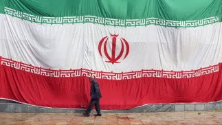 Человек на фоне флага Исламской Республики Иран. Фотоиллюстрация. Fot. PAP/EPA/ABEDIN TAHERKENAREH