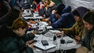 Mieszkańcy Kijowa gromadzą się w ogrzewanym namiocie, w którym można także dodładować urządzenia elektroniczne. Fot. PAP/Vladyslav Musiienko