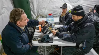 Mieszkańcy Kijowa gromadzą się w ogrzewanym namiocie, w którym można także dodładować urządzenia elektroniczne. Fot. PAP/Vladyslav Musiienko