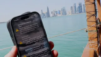 Komunikat o ataku na Katar wyświetlony na telefonie komórkowym. Fot. PAP/EPA/Hannibal Hanschke