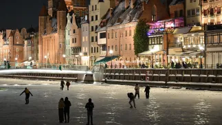 Spacerowicze i łyżwiarze na zamarzniętej rzece Motławie w Gdańsku. Fot. PAP/Adam Warżawa