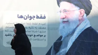 Женщина в чадре идет мимо плаката с изображением верховного лидера Ирана аятоллы Али Хаменеи на церемонию памяти погибших в антиправительственных протестах в Иране. Тегеран, Исламская Республика Иран. 17 февраля 2026 года. Fot. PAP/EPA/ABEDIN TAHERKENAREH