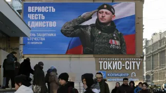 Ludzie przechodzą obok billboardu podczas „Dnia Obrońcy Ojczyzny” w Petersburgu w Rosji Fot. PAP/EPA/ANATOLY MALTSEV