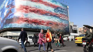 Іранці йдуть поруч з величезним антиамериканським білбордом на вулиці в Тегерані, Іран, 25 лютого 2026 року. Fot. PAP/EPA/ABEDIN TAHERKENAREH