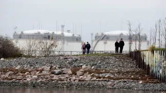 Люди прогулюються берегом Фінської затоки на тлі Санкт-Петербурзького нафтового терміналу. Фотоілюстрація. Fot. PAP/EPA/ANATOLY MALTSEV 
