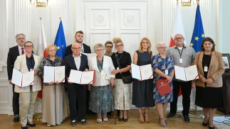 Prezes Towarzystwa Przyjaciół Ratowic Beata Jagielska (P) podczas wręczenia not identyfikacyjnych rodzinom ofiar zbrodni wołyńskiej w Puźnikach. Fot. PAP/Marcin Obara