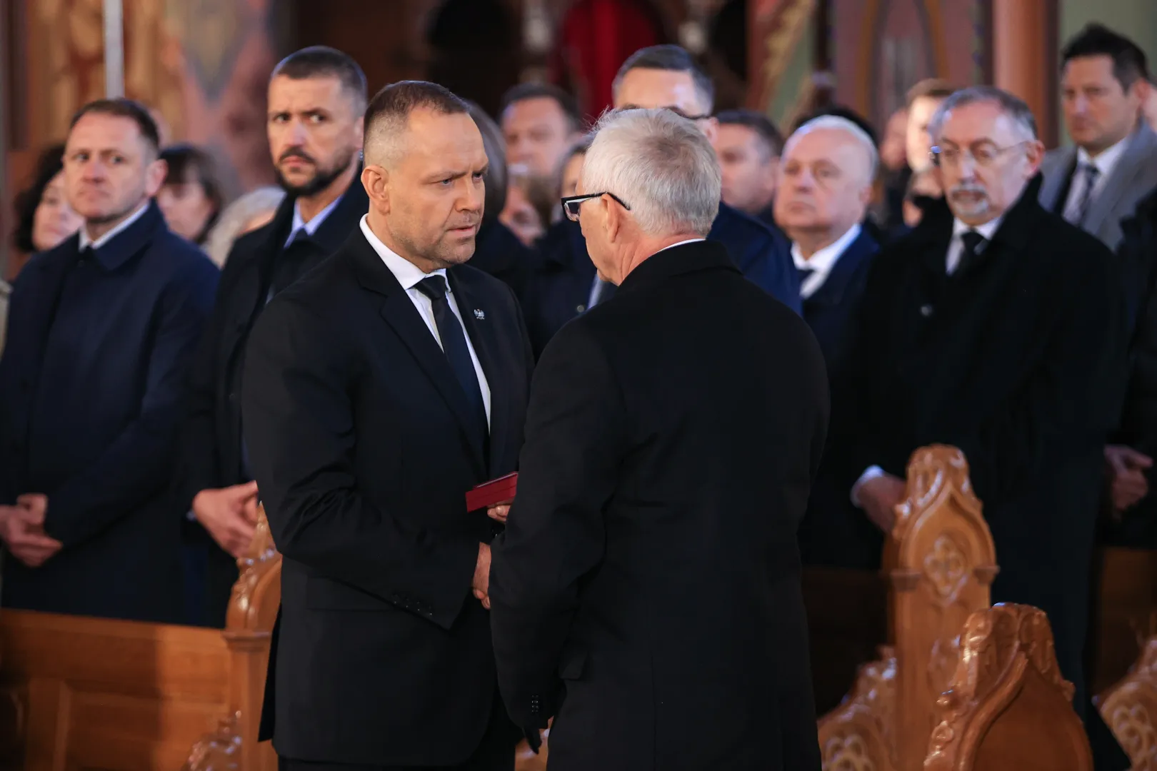 Prezydent RP Karol Nawrocki (L) odznaczył pośmiertnie posła Łukasza Litewkę Krzyżem Oficerskim Orderu Odrodzenia Polski w kościele parafii rzymskokatolickiej pw. św. Joachima w Sosnowcu. Fot. PAP/Jarek Praszkiewicz