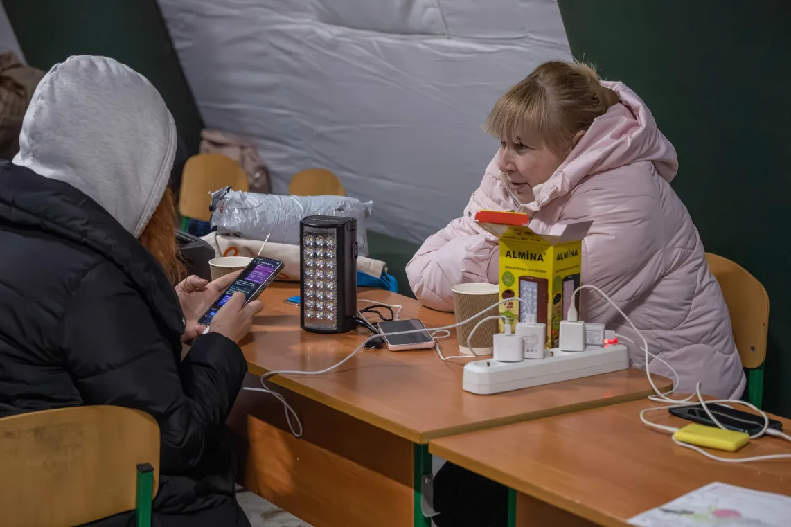 Mieszkańcy Kijowa gromadzą się w ogrzewanym namiocie, w którym można także dodładować urządzenia elektroniczne. Fot. PAP/Vladyslav Musiienko