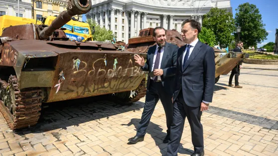 Очільник польської дипломатичної місії в Польщі Пьотр Лукасєвич та міністр фінасів й економіки Польщі Анджей Доманьский на фоні знищеної російської техніки в Києві. Fot. PAP/Vladyslav Musiienko