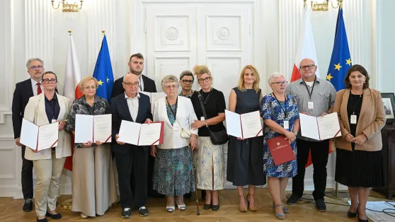 Prezes Towarzystwa Przyjaciół Ratowic Beata Jagielska (P) podczas wręczenia not identyfikacyjnych rodzinom ofiar zbrodni wołyńskiej w Puźnikach. Fot. PAP/Marcin Obara