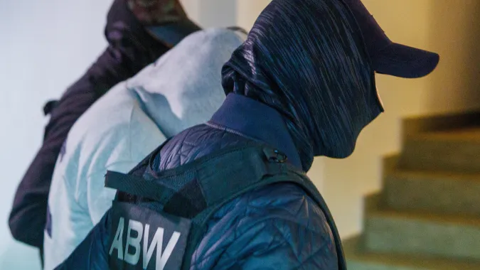 Funkcjonariusze ABW prowadzący zatrzymanego. Fot. PAP/Krzysztof Ćwik 