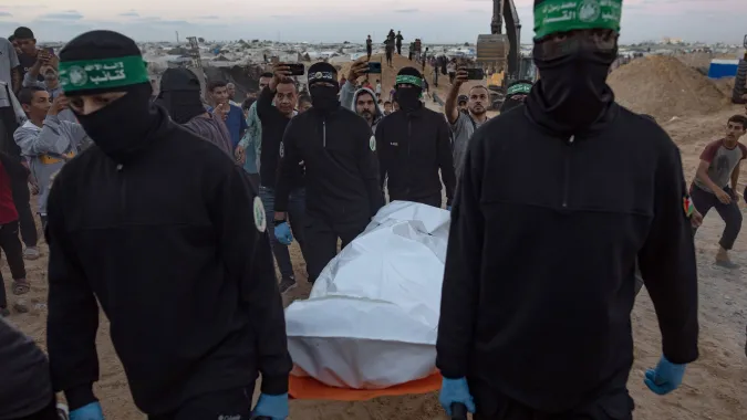 Członkowie Hamasu przekazują zakładnika stronie izraelskiej, fot. PAP/EPA/HAITHAM IMAD