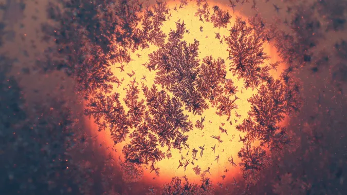 Wschód słońca zza szyby pokrytej szronem Fot. PAP/EPA/MAXIM SHIPENKOV