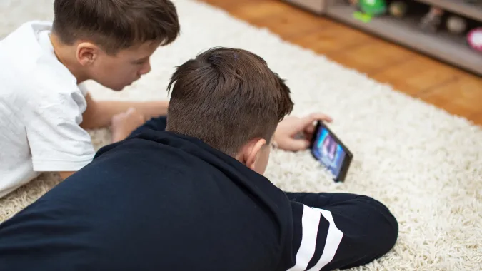 Dzieci z telefonem (zdjęcie ilustracyjne). Fot. Adobe Stock/sakkmesterke
