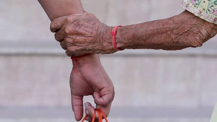 Ręka starszej osoby trzyma rękę młodszejFot. PAP/EPA/HARISH TYAGI 