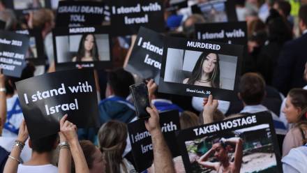 Protestujący Izraelczycy trzymający banery ze zdjęciami osób zamordowanych i porwanych do niewoli, fot. PAP/EPA/NEIL HALL