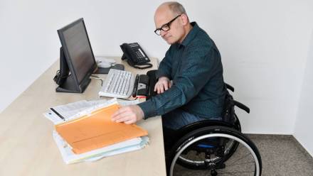 Mężczyzna na wózku inwalidzkim w pracy Fot. PAP/DPA/Frank May