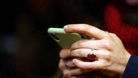 Kobieta trzymająca telefon. Zdj. ilustracyjne. Fot. PAP/EPA/ABEDIN TAHERKENAREH 