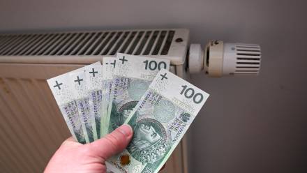 Banaknoty na tle kaloryfera. Fot. PAP/Marcin Bielecki