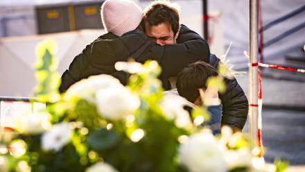 Ludzie pocieszają się nawzajem w pobliżu baru, gdzie wybuchł pożar w wyniku eksplozji Fot. PAP/EPA/JEAN-CHRISTOPHE BOTT