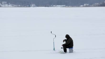Wędkarz podlodowy na zamarzniętym jeziorze Niegocin Fot. PAP/Tomasz Waszczuk