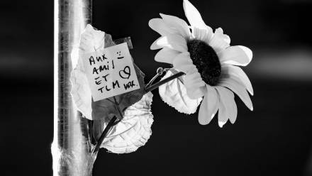 Kwiaty w pobliżu miejsca, gdzie wybuchł pożar w barze i salonie Le Constellation. Fot. PAP/EPA/JEAN-CHRISTOPHE BOTT