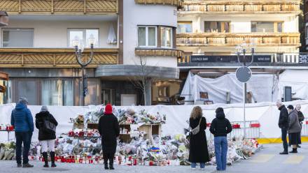 Kwiaty i znicze przed miejscem tragedii w Crans-Montanie, fot. PAP/EPA/KEYSTONE/CYRIL ZINGARO