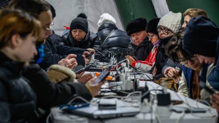 ieszkańcy Kijowa gromadzą się w ogrzewanym namiocie, w którym można także dodładować urządzenia elektroniczne. Fot. PAP/Vladyslav Musiienko