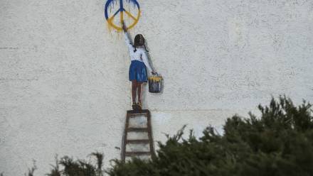 Graffiti autorstwa włoskiego artysty TV Boya na murze budynku w Buczy. Fot. PAP/	Vladyslav Musiienko