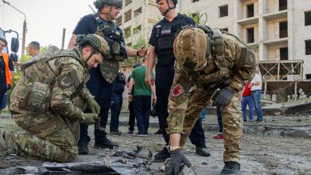 Saperzy zbierają fragmenty rosyjskiej lotniczej bomby kierowanej (KAB) w Charkowie. Fot. PAP/Mykola Kalyeniak