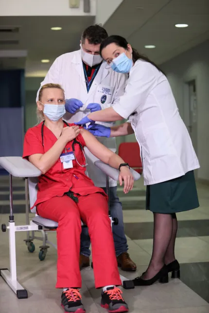 Lekarz chorób zakaźnych Agnieszka Szarowska (L) i zastępca dyrektora ds. medycznych dr n. med. Artur Zaczyński (C) podczas szczepienia przeciw koronawirusowi Covid-19 na terenie Centralnego Szpitala Klinicznego MSWiA w Warszawie. Fot. PAP/Leszek Szymański